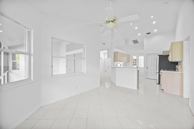 interior space with high vaulted ceiling, ceiling fan, and light tile patterned flooring