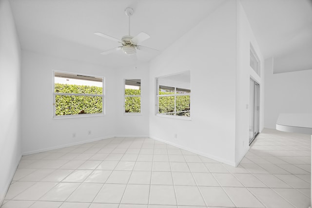 tiled empty room featuring ceiling fan, high vaulted ceiling, and a healthy amount of sunlight