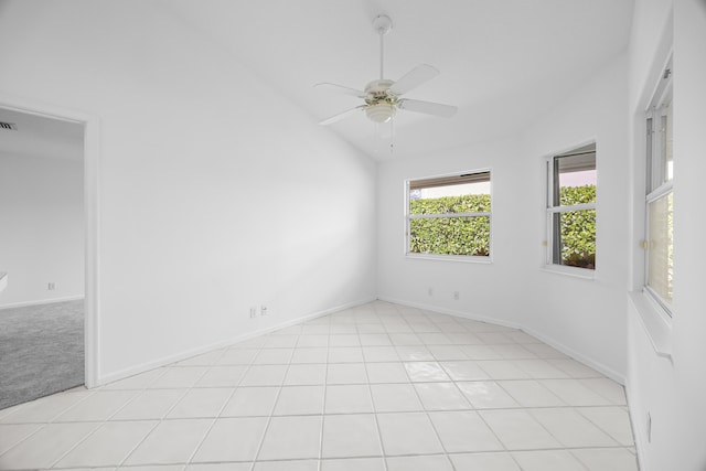 spare room featuring vaulted ceiling, light tile patterned floors, and ceiling fan