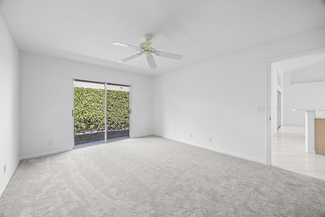 carpeted empty room featuring ceiling fan and a textured ceiling