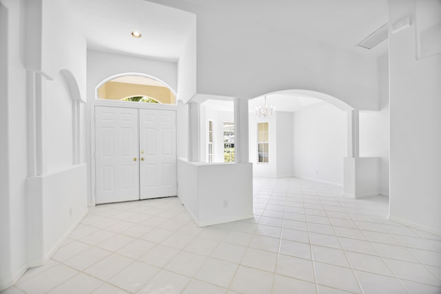 tiled foyer featuring a chandelier