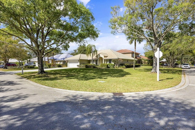 ranch-style house featuring a garage and a front yard