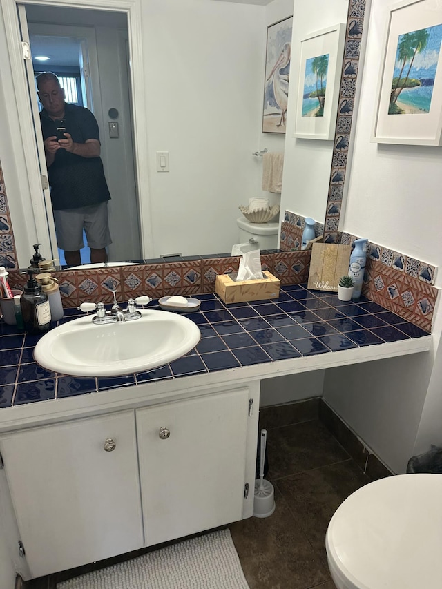 bathroom featuring tile patterned flooring, vanity, and toilet