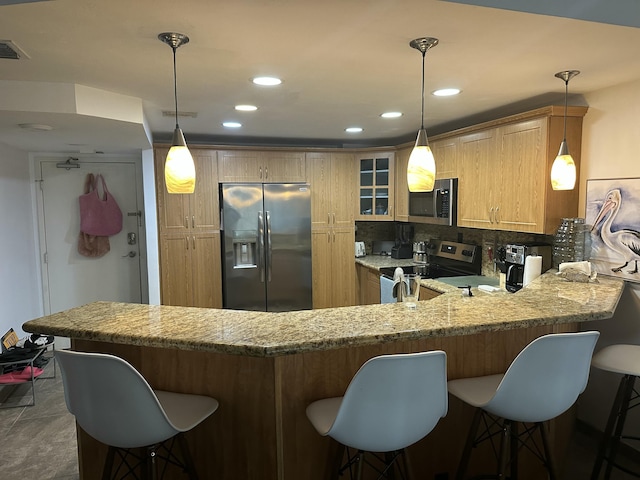 kitchen featuring pendant lighting, kitchen peninsula, and appliances with stainless steel finishes