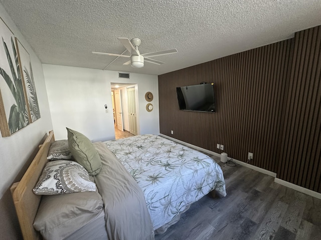 bedroom featuring hardwood / wood-style flooring, a textured ceiling, and ceiling fan