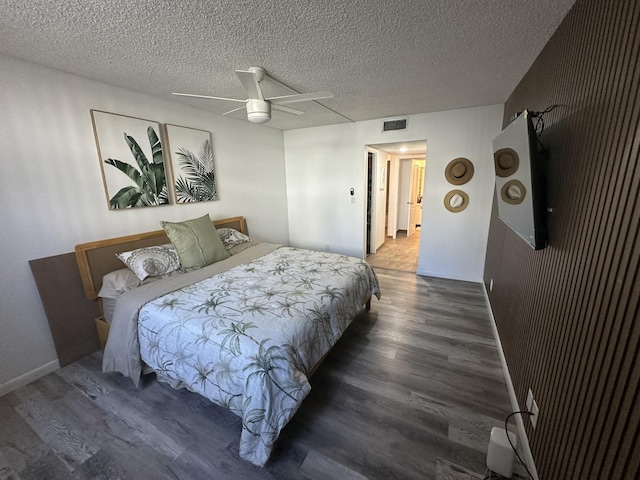 bedroom with dark wood-type flooring, ceiling fan, and a textured ceiling