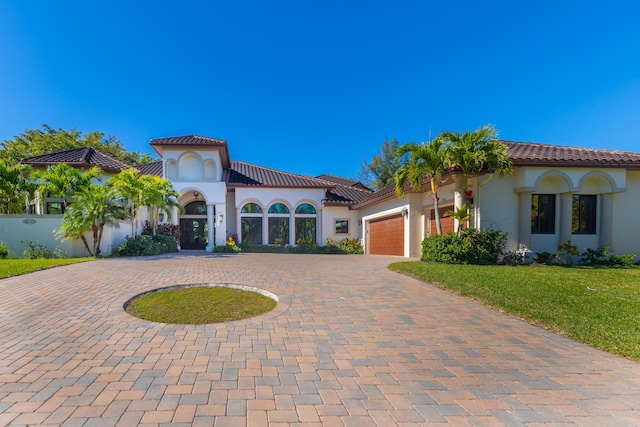 mediterranean / spanish house with a garage and a front yard