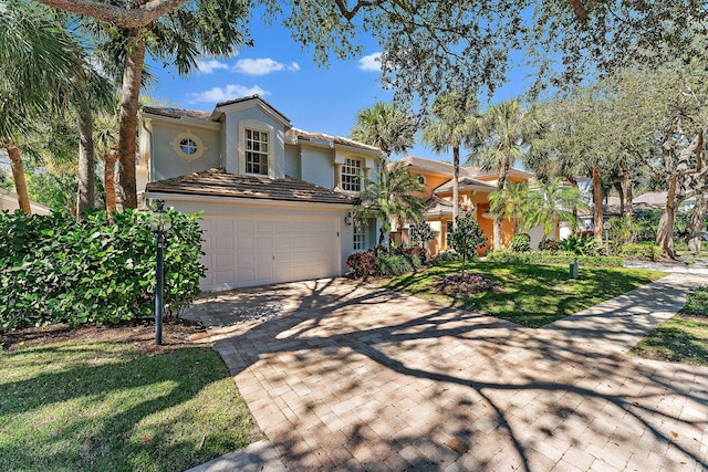 mediterranean / spanish-style house with a garage and a front yard