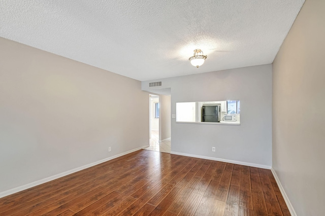 spare room with wood-type flooring and a textured ceiling