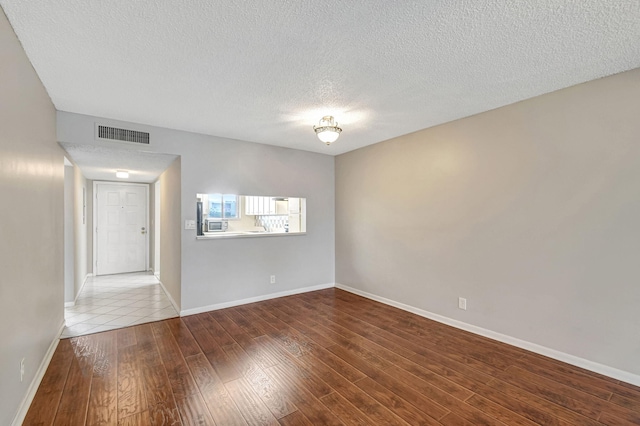 spare room featuring hardwood / wood-style flooring and a textured ceiling