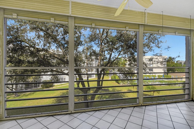 unfurnished sunroom featuring ceiling fan