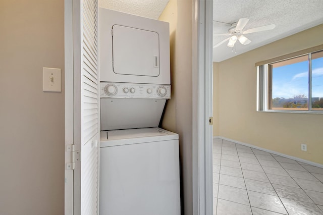 washroom featuring ceiling fan, stacked washer / drying machine, light tile patterned floors, and a textured ceiling