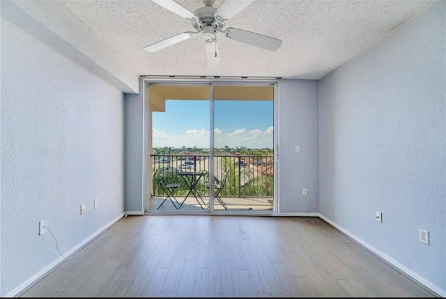 empty room featuring hardwood / wood-style flooring, floor to ceiling windows, and a textured ceiling