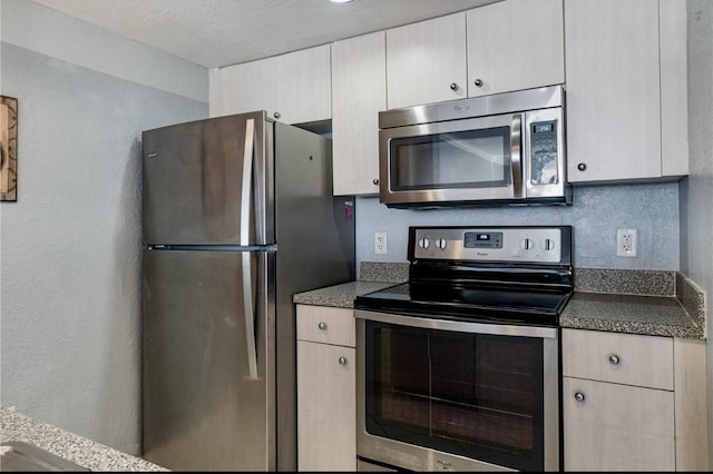 kitchen with stainless steel appliances and a textured ceiling