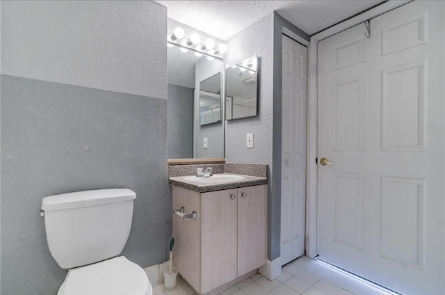 bathroom featuring tile patterned floors, vanity, and toilet