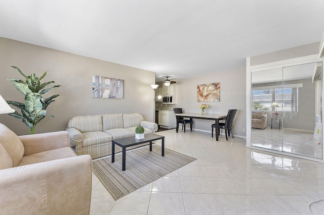 living room featuring light tile patterned floors and ceiling fan