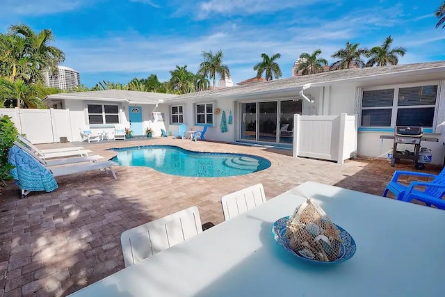 view of swimming pool featuring area for grilling and a patio area