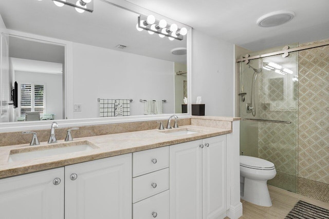 bathroom with vanity, an enclosed shower, and toilet