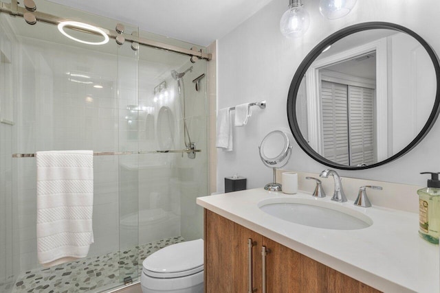 bathroom with vanity, toilet, and a shower with shower door