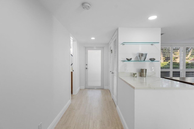 corridor with light hardwood / wood-style floors