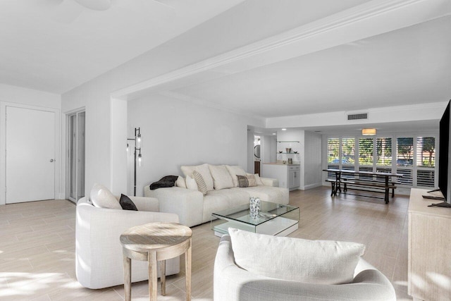 living room featuring crown molding and light wood-type flooring