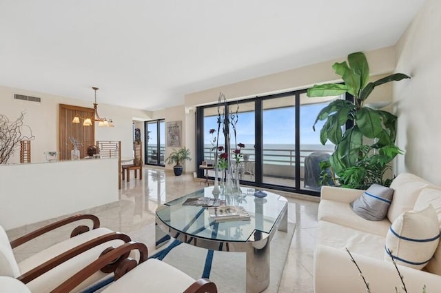 living room featuring an inviting chandelier and a water view