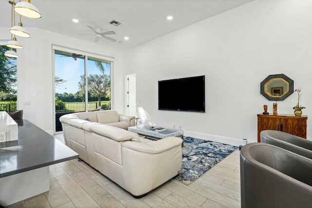 living room featuring light hardwood / wood-style floors and ceiling fan