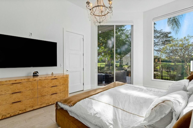 bedroom with an inviting chandelier, access to exterior, and light hardwood / wood-style flooring