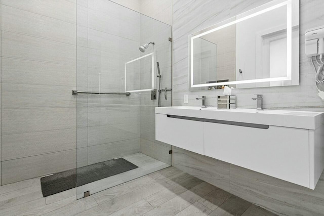 bathroom with vanity and a tile shower