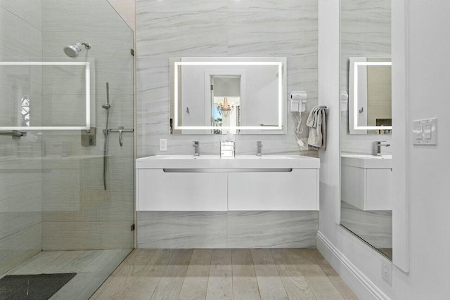 bathroom featuring tasteful backsplash, vanity, an enclosed shower, and tile walls