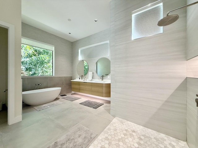 bathroom with vanity, independent shower and bath, and tile walls