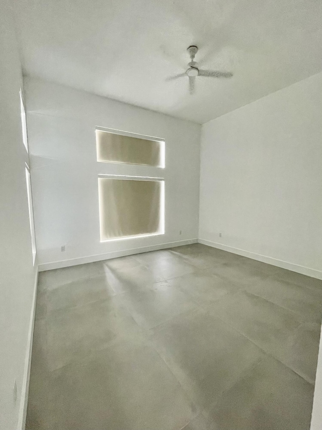 unfurnished room with concrete floors and ceiling fan