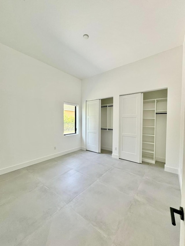 unfurnished bedroom with two closets