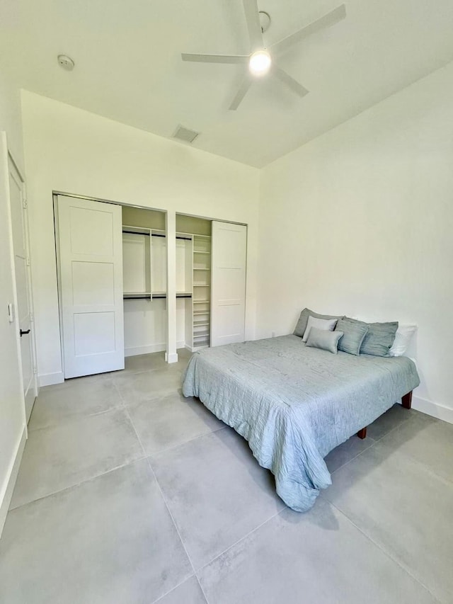 bedroom with multiple closets and ceiling fan