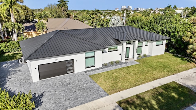 view of front of property featuring a garage and a front lawn