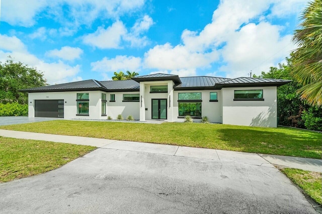 751 Pelican Way, North Palm Beach, FL 33408 - prairie-style house featuring a standing seam roof, stucco siding, concrete driveway, a front yard, and metal roof