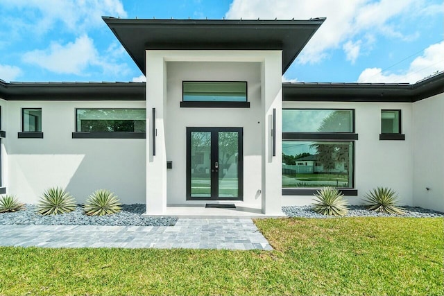 751 Pelican Way, North Palm Beach, FL 33408 - entrance to property featuring stucco siding and a lawn