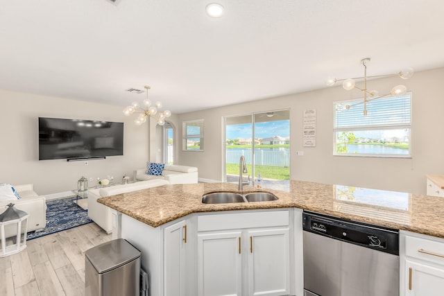 kitchen featuring sink, white cabinetry, stainless steel dishwasher, pendant lighting, and light stone countertops