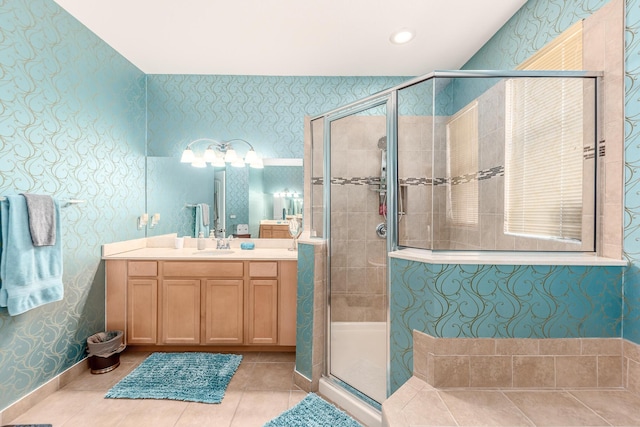 bathroom with tile patterned flooring, vanity, and walk in shower