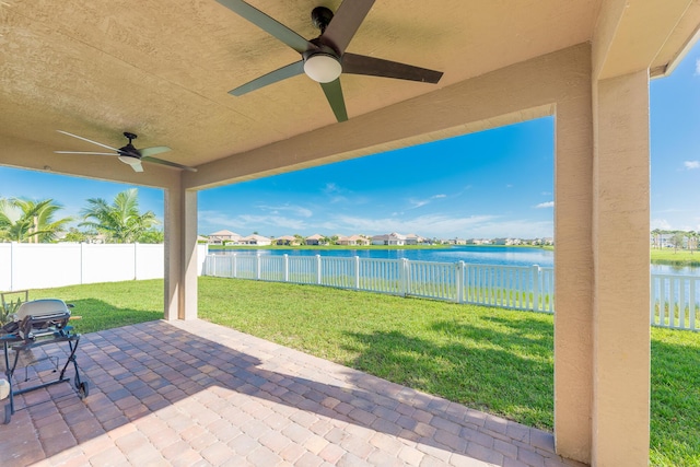 view of patio with a water view and ceiling fan