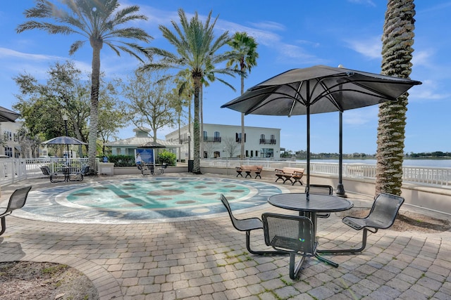 view of swimming pool featuring a patio area, a hot tub, and a water view