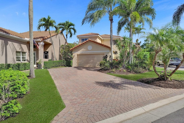 mediterranean / spanish home featuring a garage and a front lawn