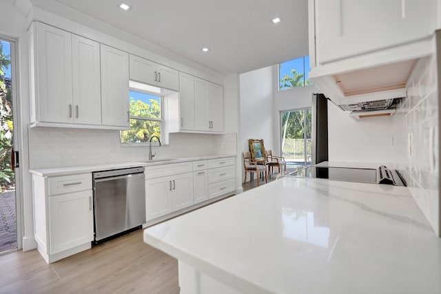 kitchen featuring backsplash, dishwasher, sink, and white cabinets