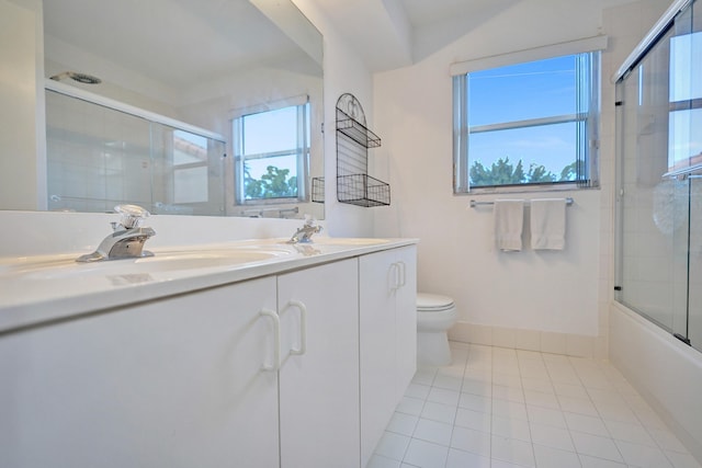 full bathroom with tile patterned flooring, vanity, combined bath / shower with glass door, and toilet