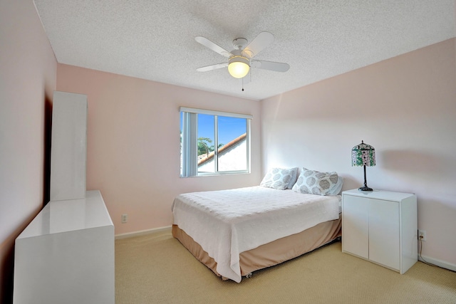 carpeted bedroom featuring ceiling fan and a textured ceiling