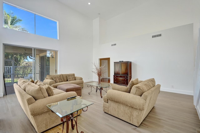 living room featuring a high ceiling and light wood-type flooring