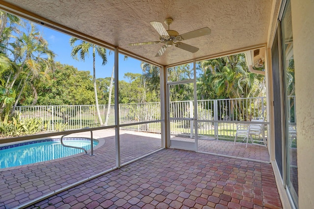 unfurnished sunroom featuring ceiling fan