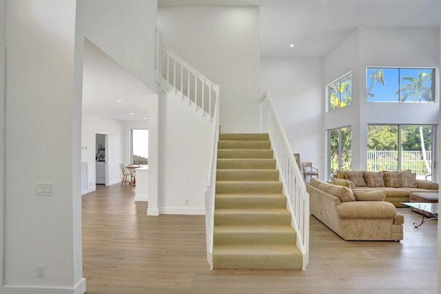 stairs featuring hardwood / wood-style flooring and a high ceiling