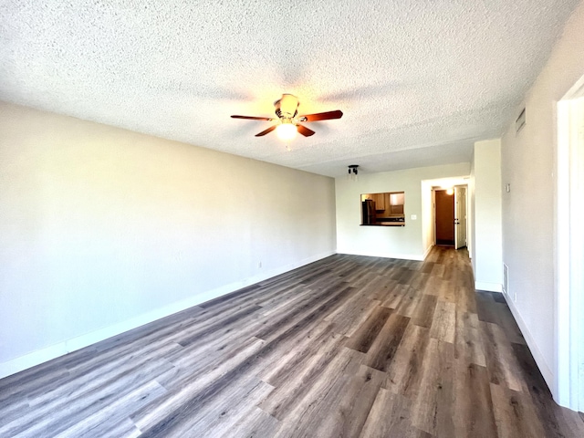 unfurnished living room featuring dark wood-type flooring, a textured ceiling, and ceiling fan