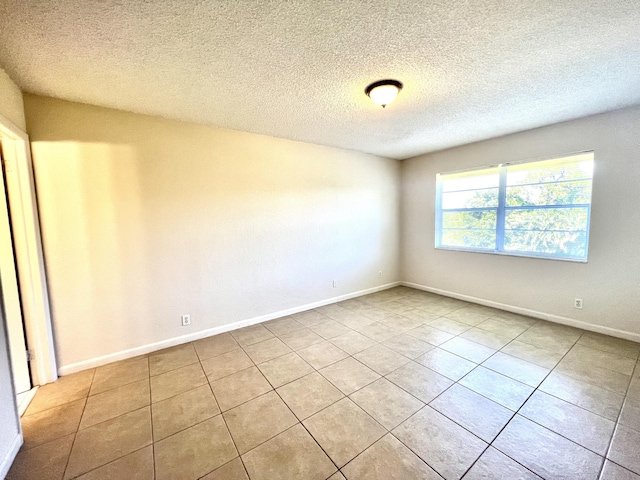 tiled spare room with a textured ceiling